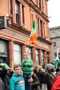 A boy hold an Ireland flag and stood on the high place on St. Patrick`s Day ParadeÃÂ in Dublin, Ireland, March 18th 2015